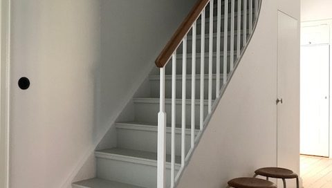 Vitmålad trappa med stålsmide.