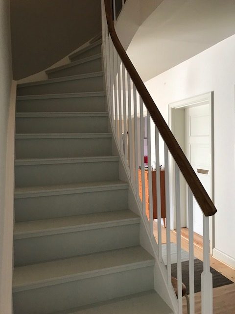 Vitmålad trappa med stålsmide.